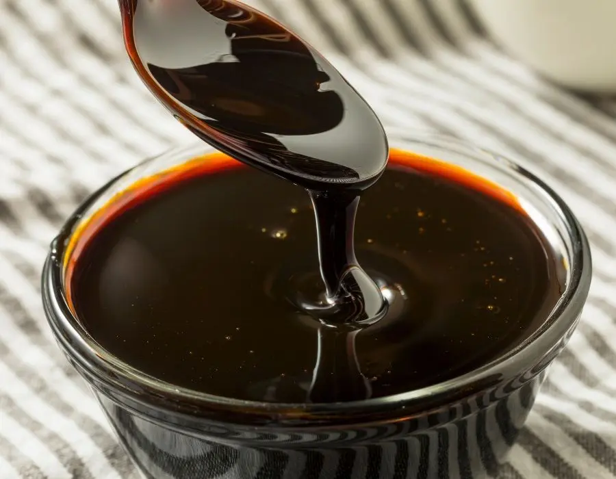 Spoon spooning molasses from glass jar to be used for cannabis nutrients